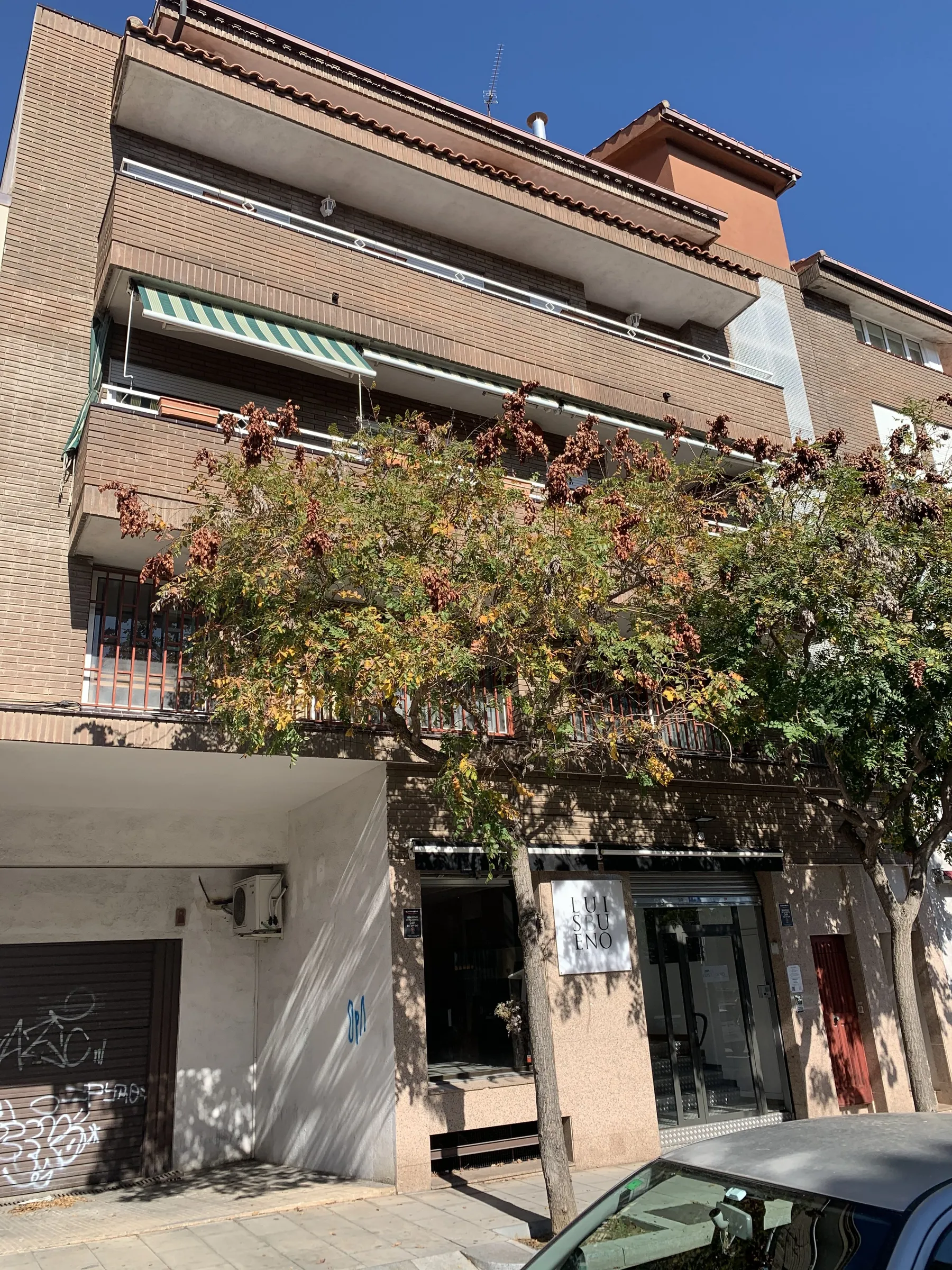 Fachada de ladrillo visto con terrazas y toldos del edificio de la calle Altimira