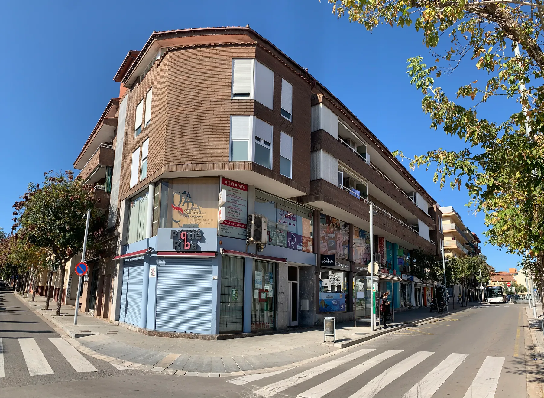 Edificio de viviendas de ladrillo visto en esquina, con locales en planta baja, en el centro de Cerdanyola del Vallès